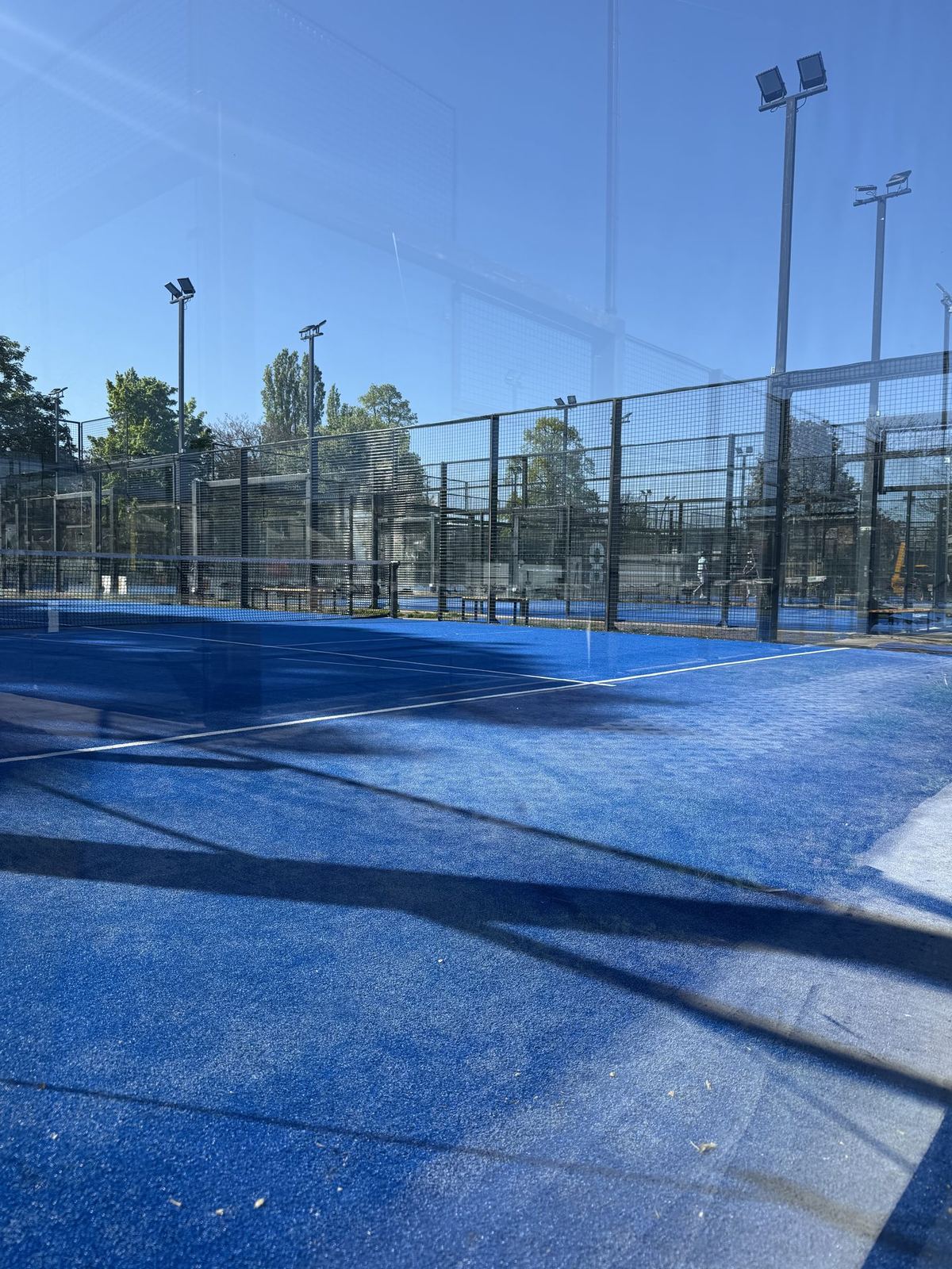 Mehrere Padel-Courts in Reihe mit Flutlichtmasten